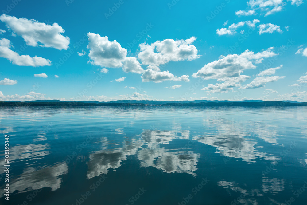 Fototapeta premium Russia. The Southern Urals. Lake Turgoyak. Clouds reflected on the water surface of the lake in clear weather. 