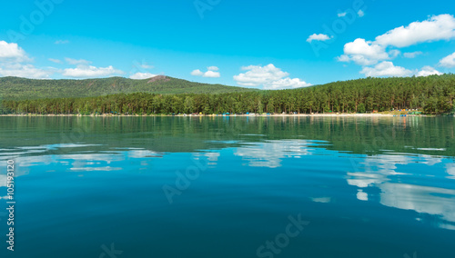 Russia. The Southern Urals. Lake Turgoyak. Clouds reflected on the water surface of the lake in clear weather. 