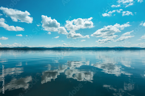 Fototapeta Naklejka Na Ścianę i Meble -  Russia. The Southern Urals. Lake Turgoyak.
Clouds reflected on the water surface of the lake in clear weather.
