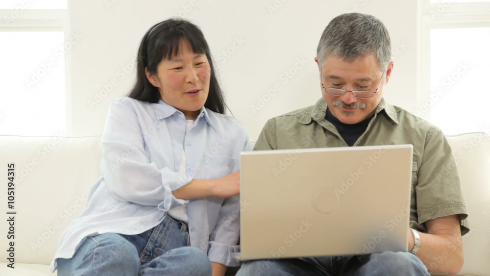 Mature Asian couple using laptop computer Mature Asian couple using laptop computer