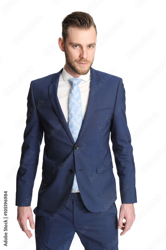 Trendy businessman standing against a white background wearing a blue suit, white shirt and a light blue tie. Staring at camera.