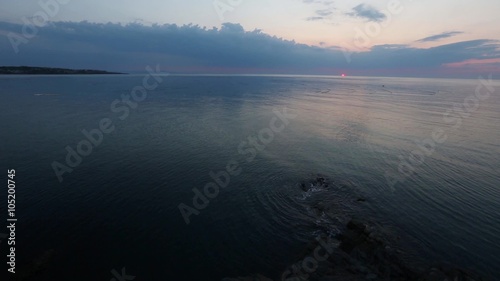 Morning sea view with sunrise and buoys of fishing nets on water surface.
