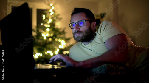 Man browsing internet on laptop and relaxing at home
 photo