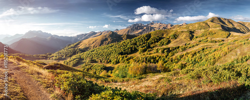 The picturesque steppe mountains landscape with multicolored mountains, sparse vegetation on the background of other mountains and cloudy sky in autumn