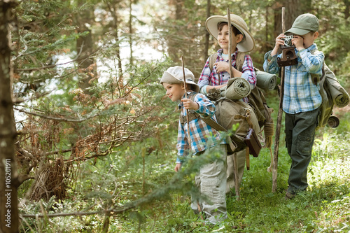 Boys travelers on a forest trail with backpacks