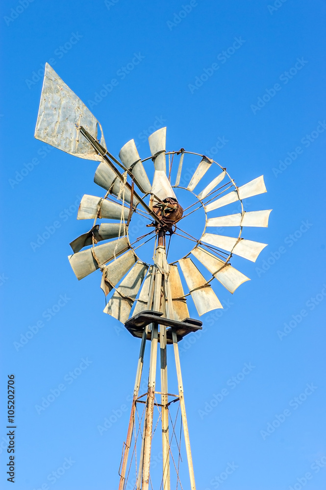 Old rusty windmill with some broken blades Old rusty windmill with some broken blades