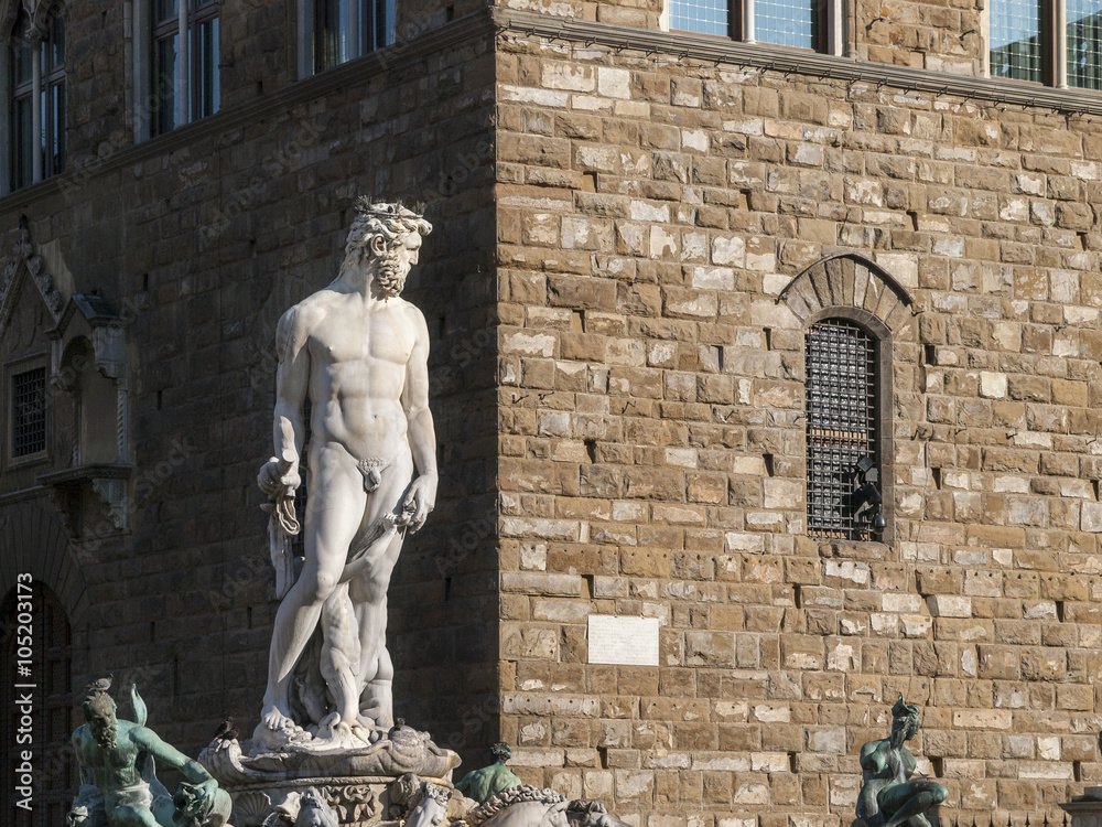 Naklejka premium Marble Statue of Neptune in Florence: A brighly lit statue of the god Neptune in the famous Piazza della Signoria in Florence