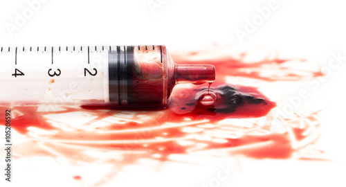 syringe and red blood on white background