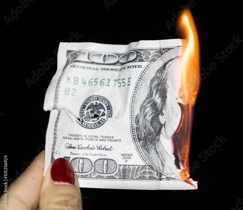 Fotografie 100 dollars burning on a black background