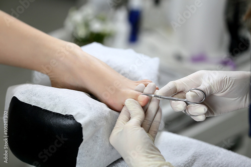 Cutting cuticle on foot  nail scissors. Pedicure