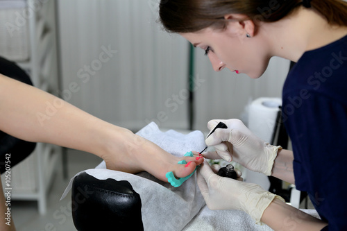 Professional pedicure master making pedicure in salon