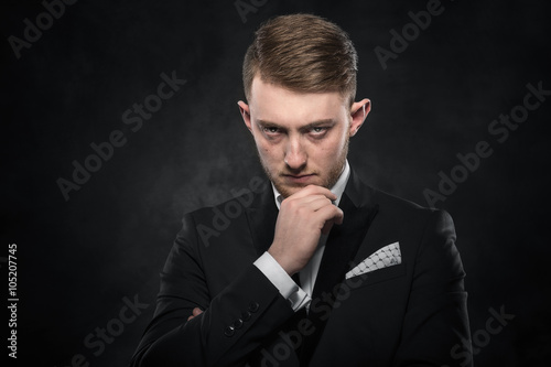 Elegant young man in suit looking frowning. © Denis Rozhnovsky