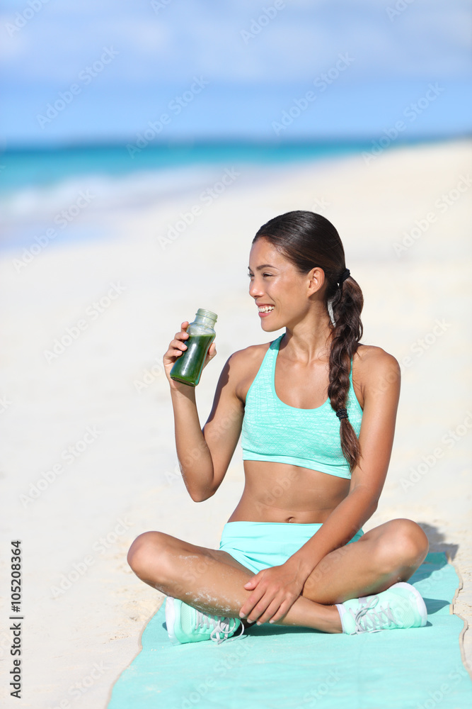 Fitness woman drinking a healthy green smoothie juice for a detox weight  loss cleanse. Happy sporty