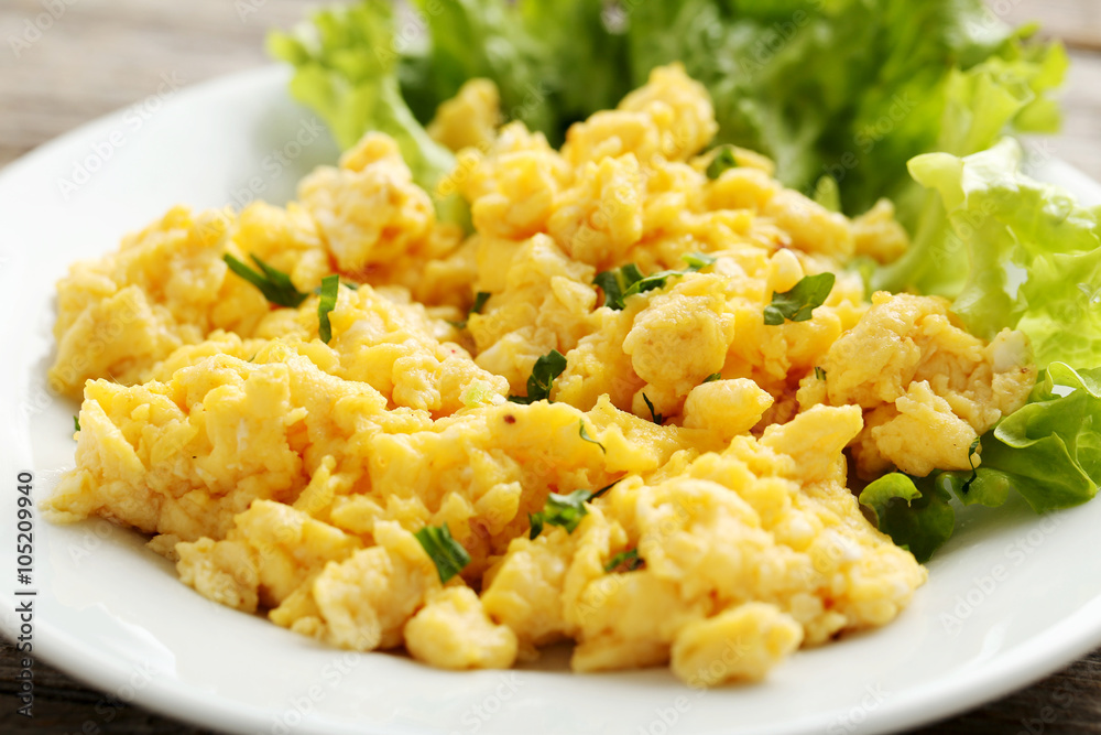 Scrambled eggs with vegetables on a grey wooden table Scrambled eggs with vegetables on a grey wooden table