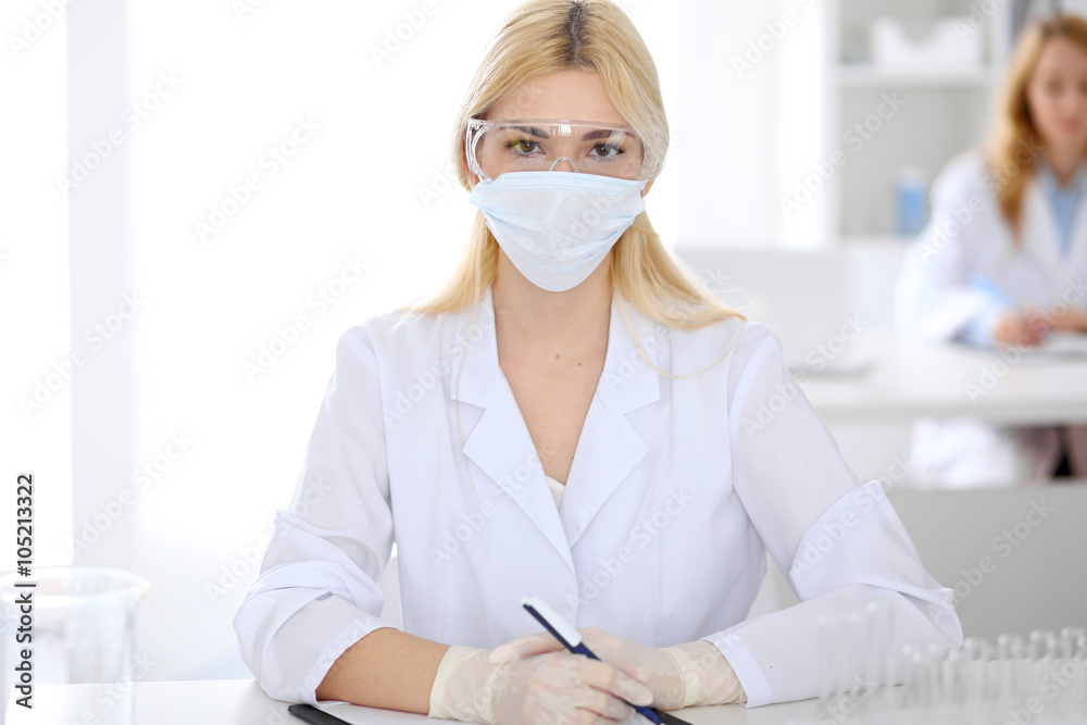 Female scientific research team with clear solution in laboratory Female scientific research team with clear solution in laboratory