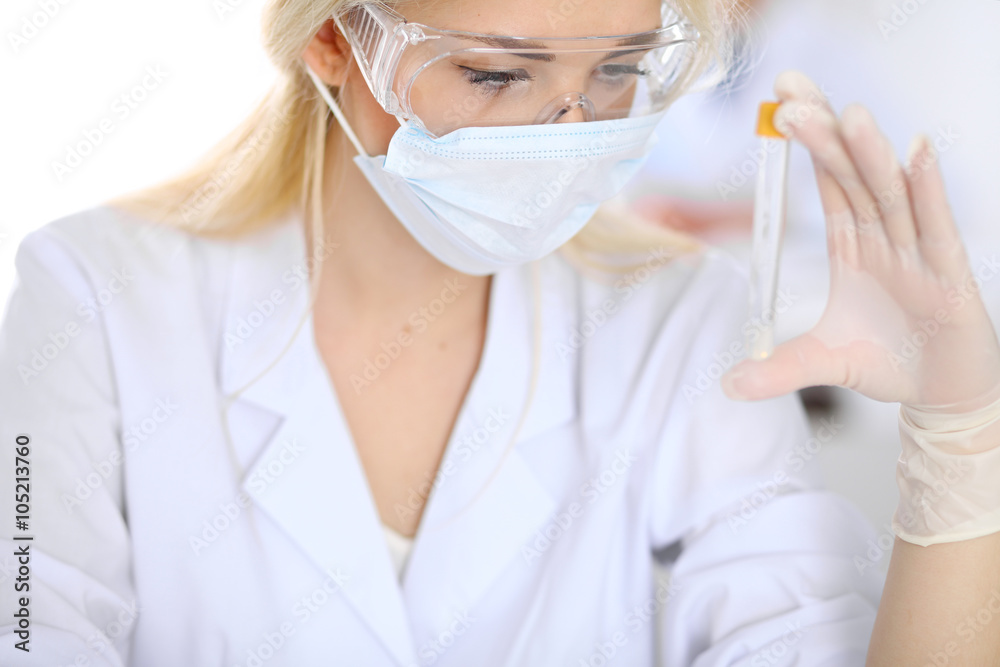 Female scientific research team with clear solution in laboratory Female scientific research team with clear solution in laboratory