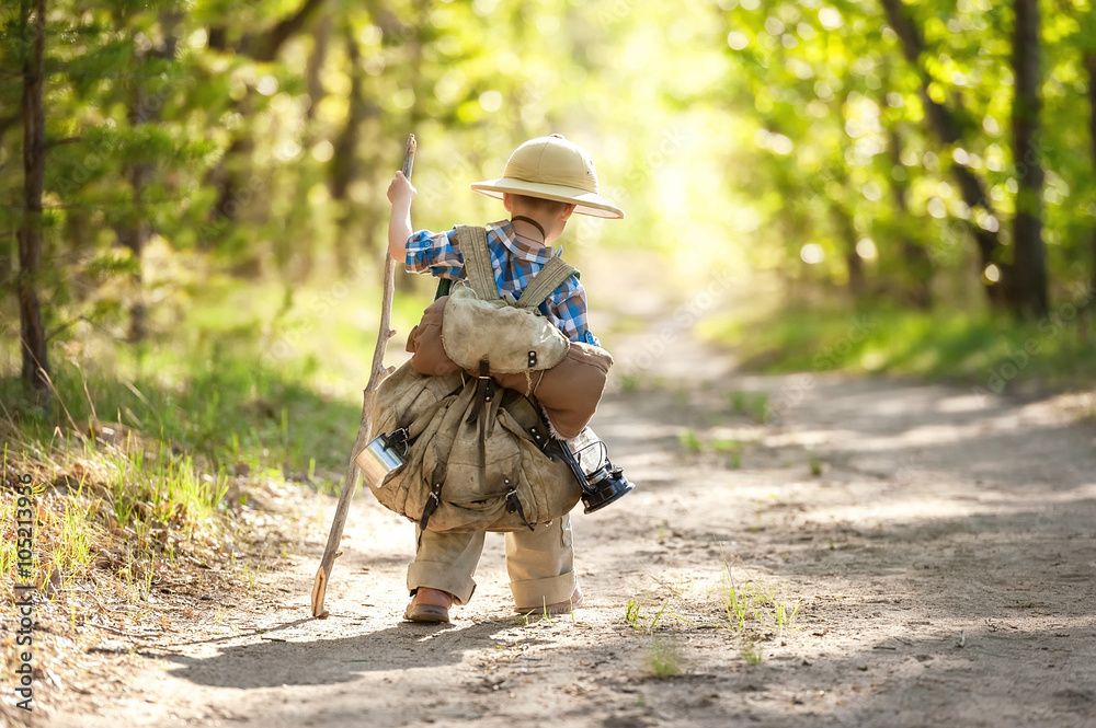 Fototapeta premium Boy on a forest road with backpacks