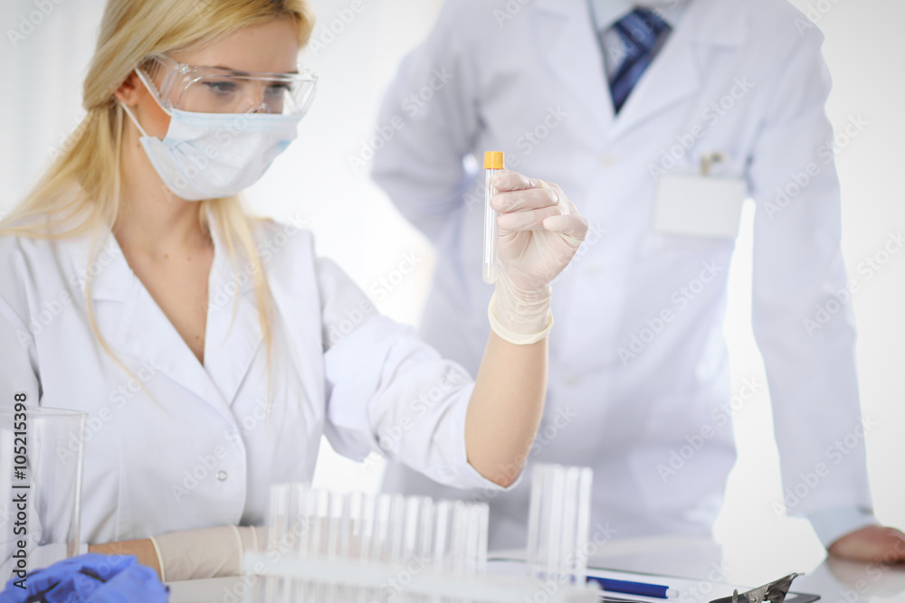 Scientific research team with clear solution in laboratory