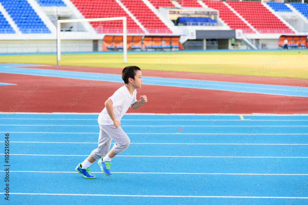 Fototapeta premium Boy runnin on blue track