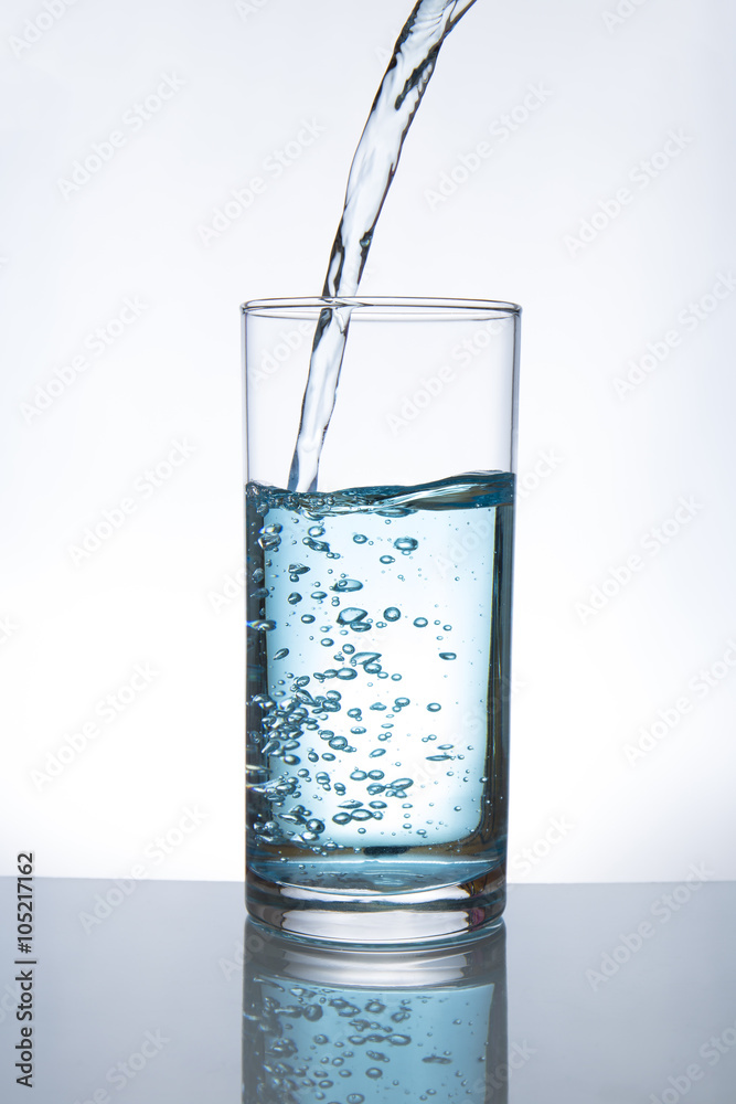Concept of drinking. Pouring water from into glass