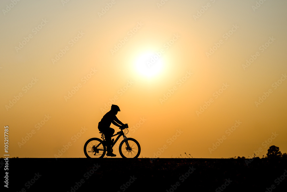 Silhouette of cyclist motion on sunset background