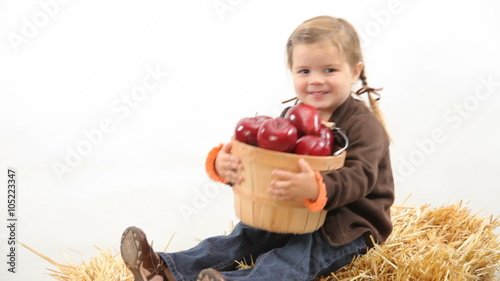 Young girl sitting with basket of apples