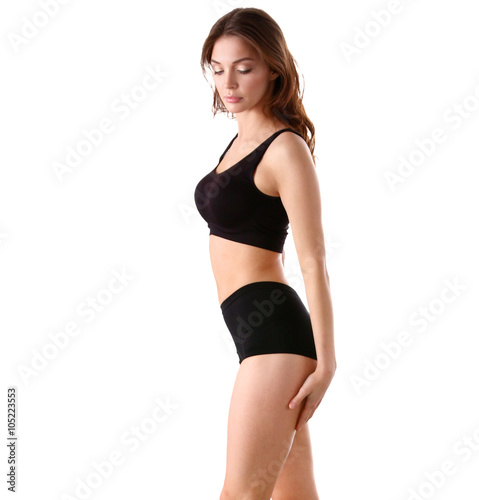 Young fitness girl standing on green grass