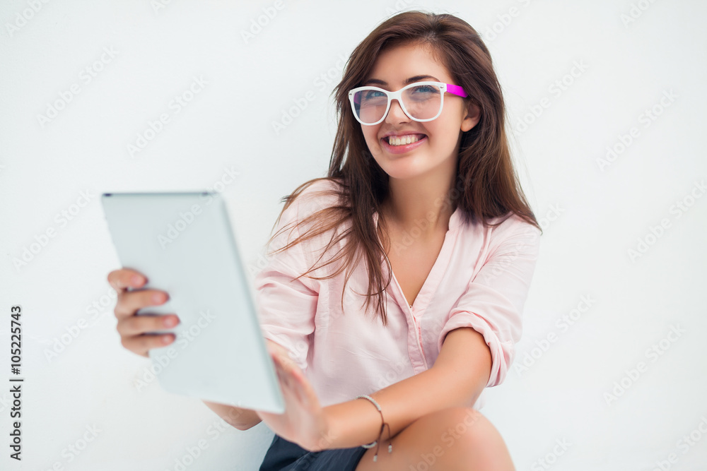 beautiful young woman in sunglasses sitting in a cafe drinking coffee/tea and work on your tablet on the Internet beautiful young woman in sunglasses sitting in a cafe drinking coffee/tea and work on your tablet on the Internet