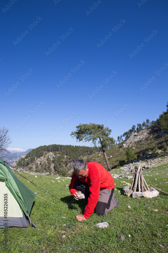 Fototapeta premium Hiker standing on top of the mountain with valley on the background.