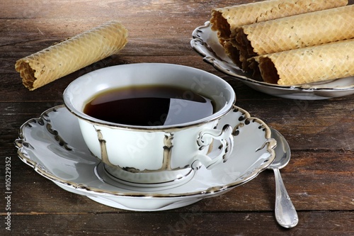 Schwarzer Tee in einer Originaltasse aus der Mitte des 19. Jahrhunderts mit ostfriesischen Neujahrsröllchen photo