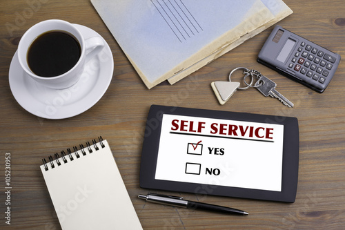 Self Service. Text on tablet device on a wooden table