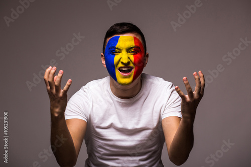 Unhappy and Failure of goal or lose game emotions of Romanian football fan in game supporting of Romania national team on grey background. European football fans concept. photo