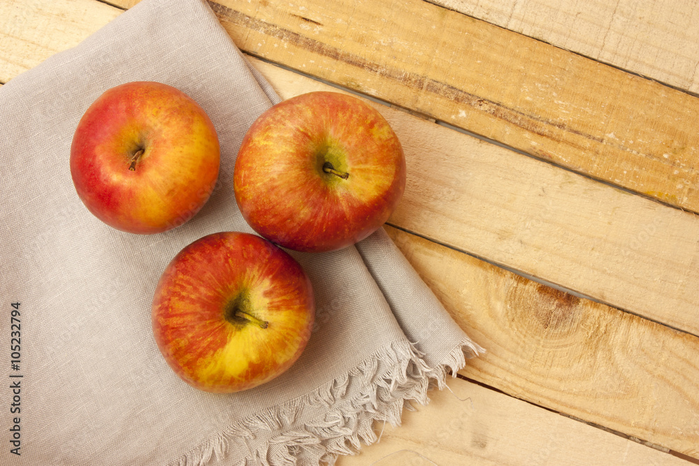 Three bright apples on napkin on wooden board, with copyspace Three bright apples on napkin on wooden board, with copyspace