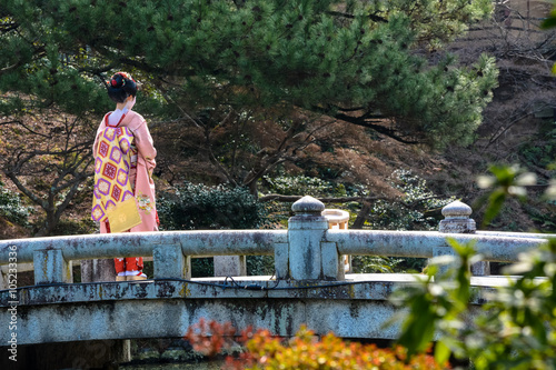 Quadro em tela Young geisha woman on a bridge in Maruyama Park, Kyoto during spring