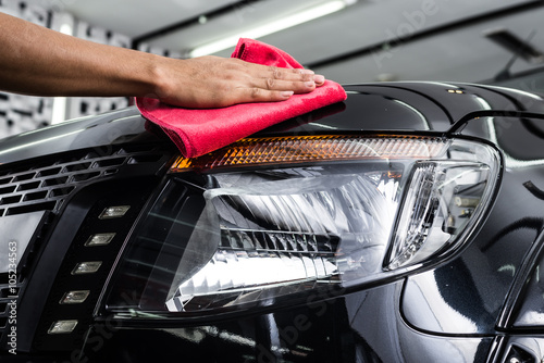 Car detailing series : Worker cleaning black car