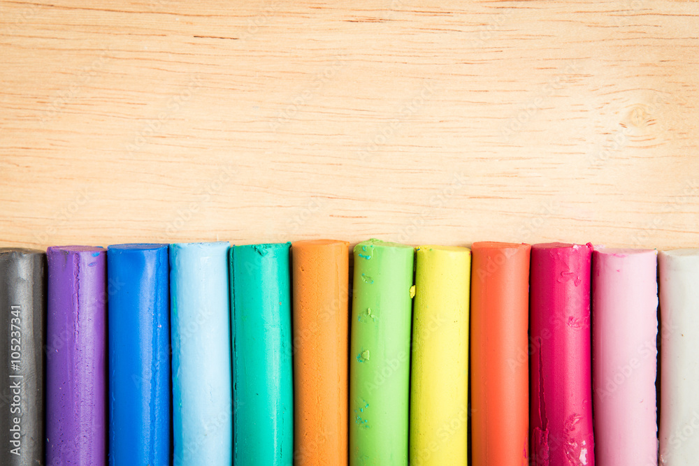 multicolor plasticine bar arrange on a wood background