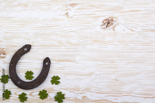 Fabric green clover leaves with horseshoe on wooden background. 
