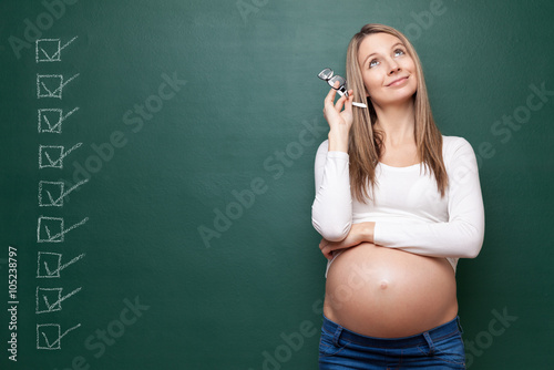 Pregnant woman and a blackboard with copyspace photo