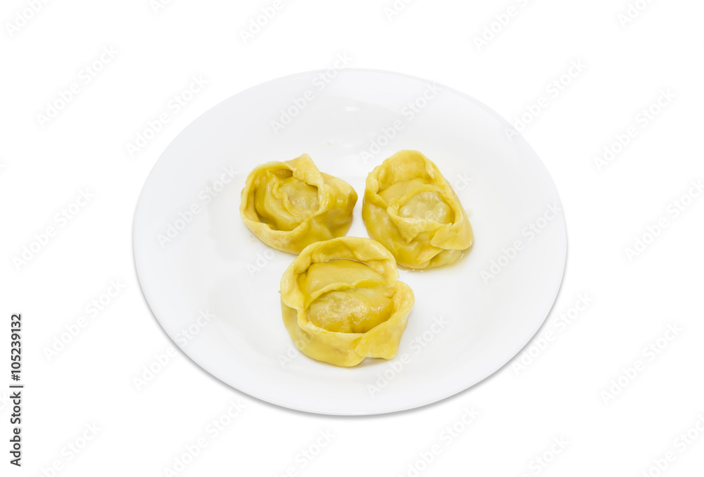 Three manti on a white dish on a light background