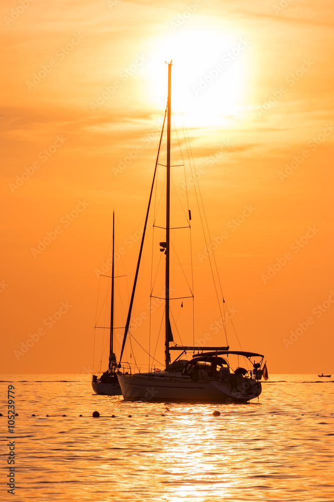Yacht in the sea at sunset hot yellow light - seascape background, vertical shot