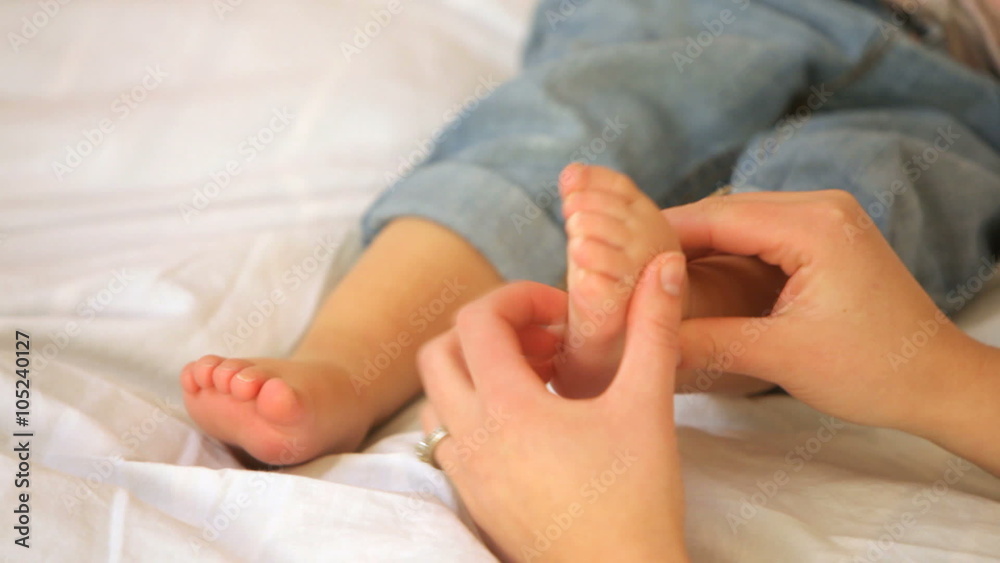 Mother tickling child's feet, closeup Mother tickling child's feet, closeup