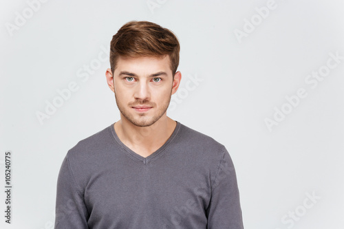 Portrait of serious handsome young man in grey pullover
