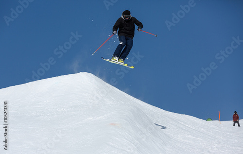 Skifahrer springt über Hügel