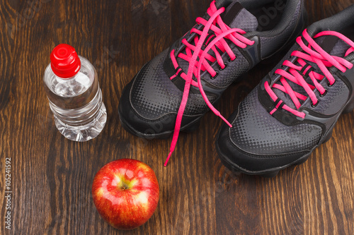 Sneakers, apple and bottle of water
