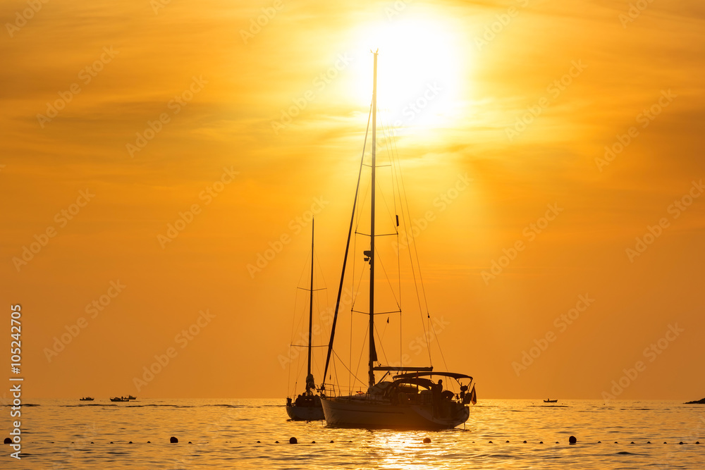 Yacht in the sea at sunset hot yellow light - seascape background