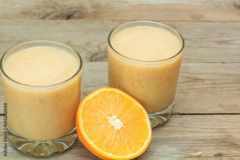couple of glasses of fruit smoothies and sliced orange couple of glasses of fruit smoothies and sliced orange