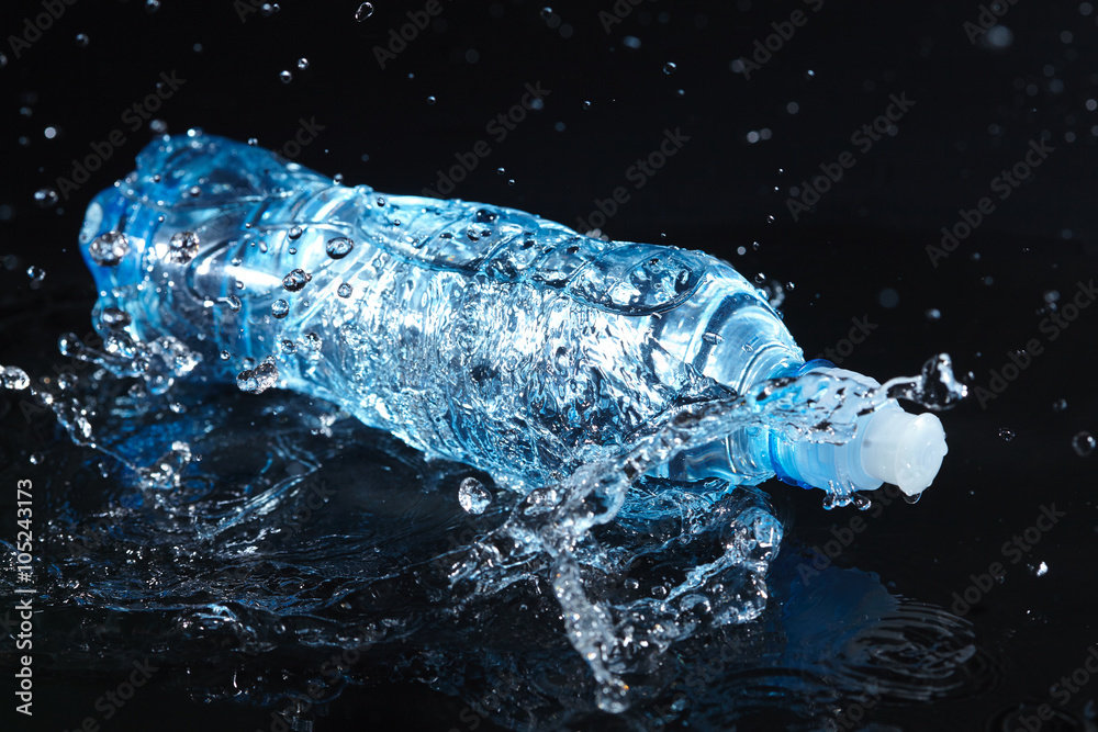 Bottle with pure water and splash around it Bottle with pure water and splash around it