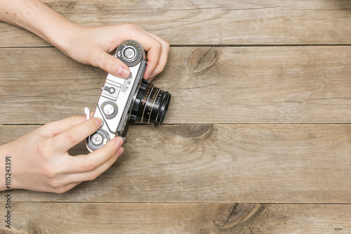 woman's hands holding a retro camera, view from above