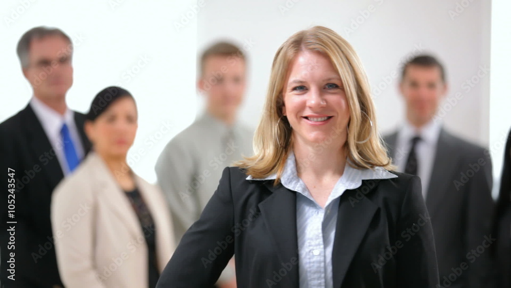 Portrait of business woman with co-workers in background Portrait of business woman with co-workers in background
