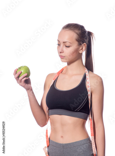 attractive fitness model with measuring tape on a white background